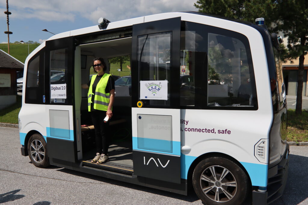 Die Eigentümerin von DigiTrans eVAN steht im Eingangsbereich eines Digibus